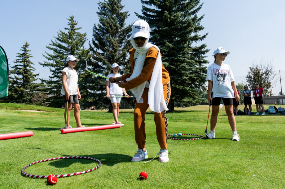 Junior golfer swinging club. 