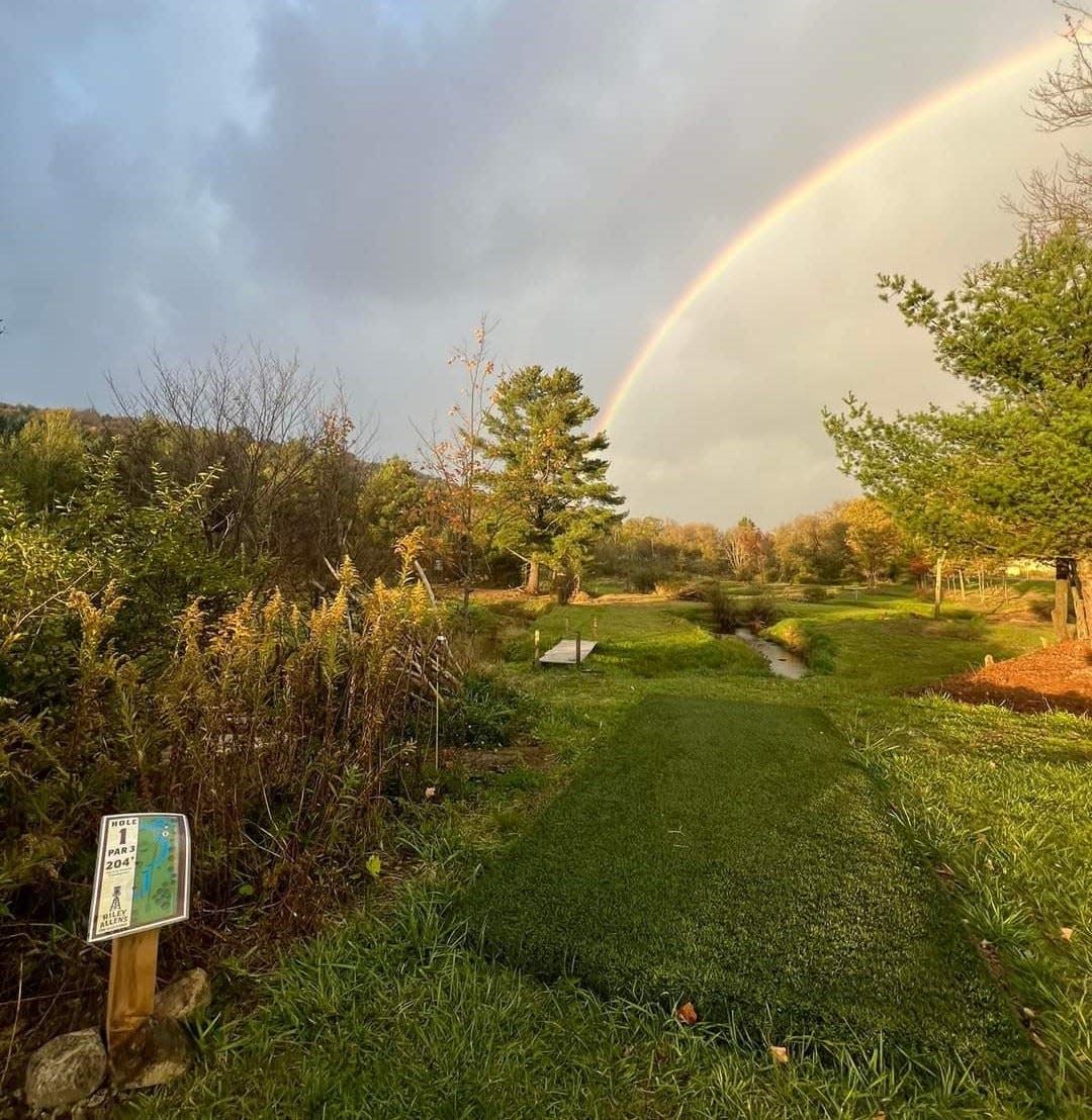 A rainbow soars over one of the holes at the new Riley Allen's Disc Golf Course in Allentown.